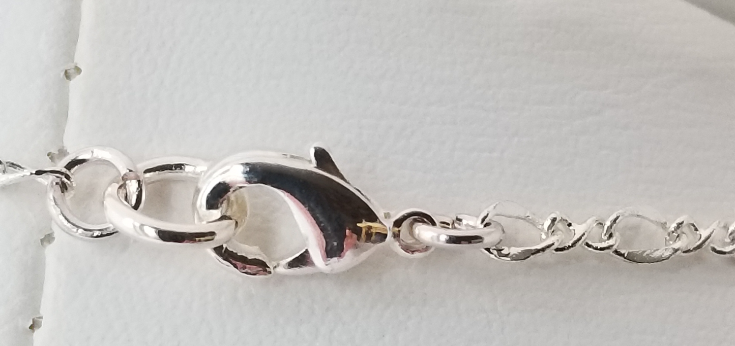 A close-up view of a silver clasp on a necklace, with the clasp and chain visible against a white background.