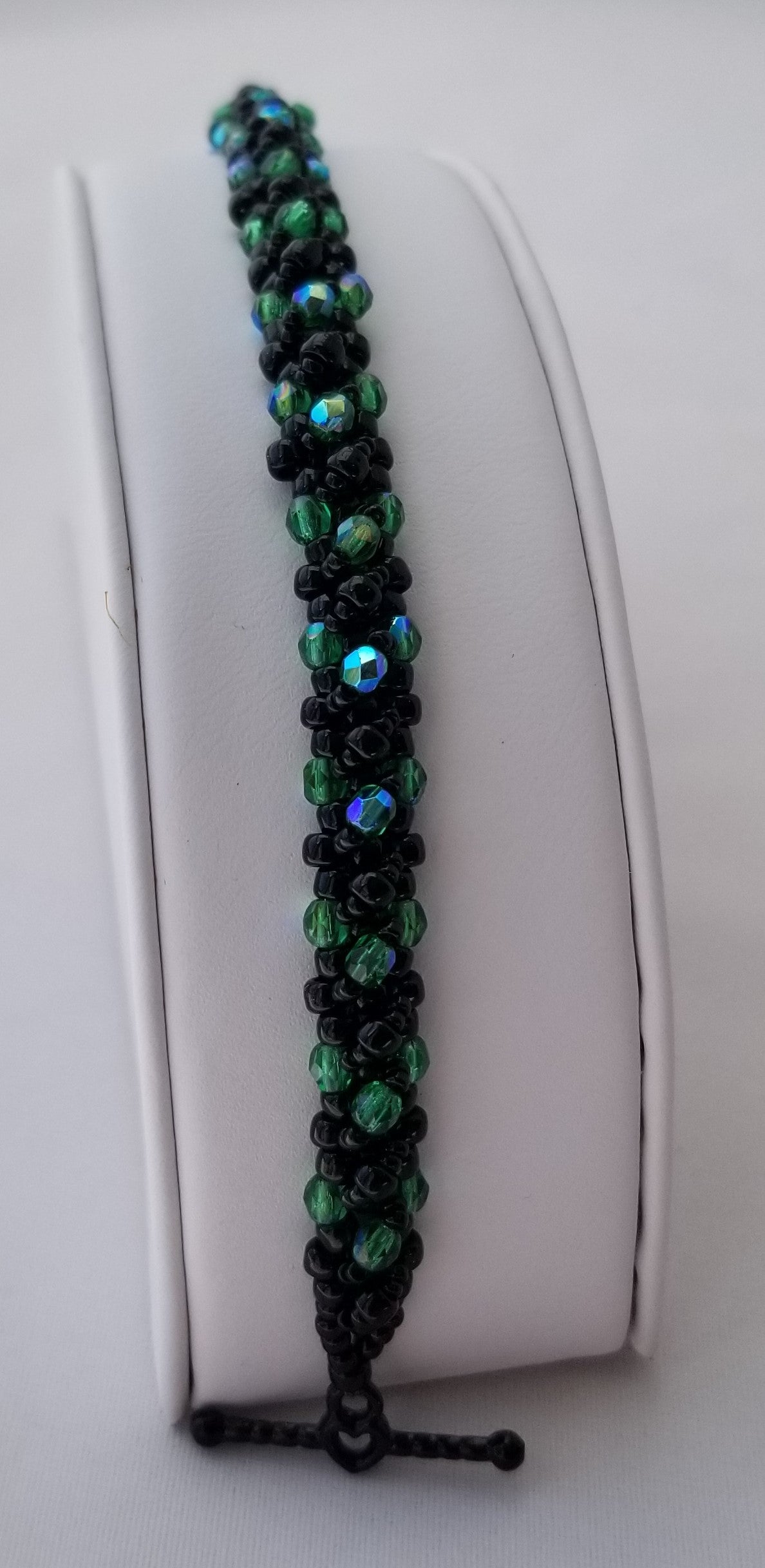 a close up of a beaded bracelet on a white surface