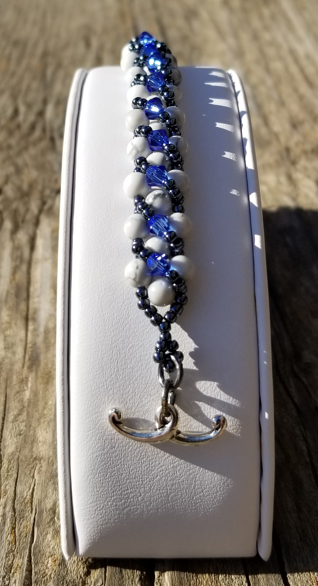 a blue and white beaded bracelet on a white case