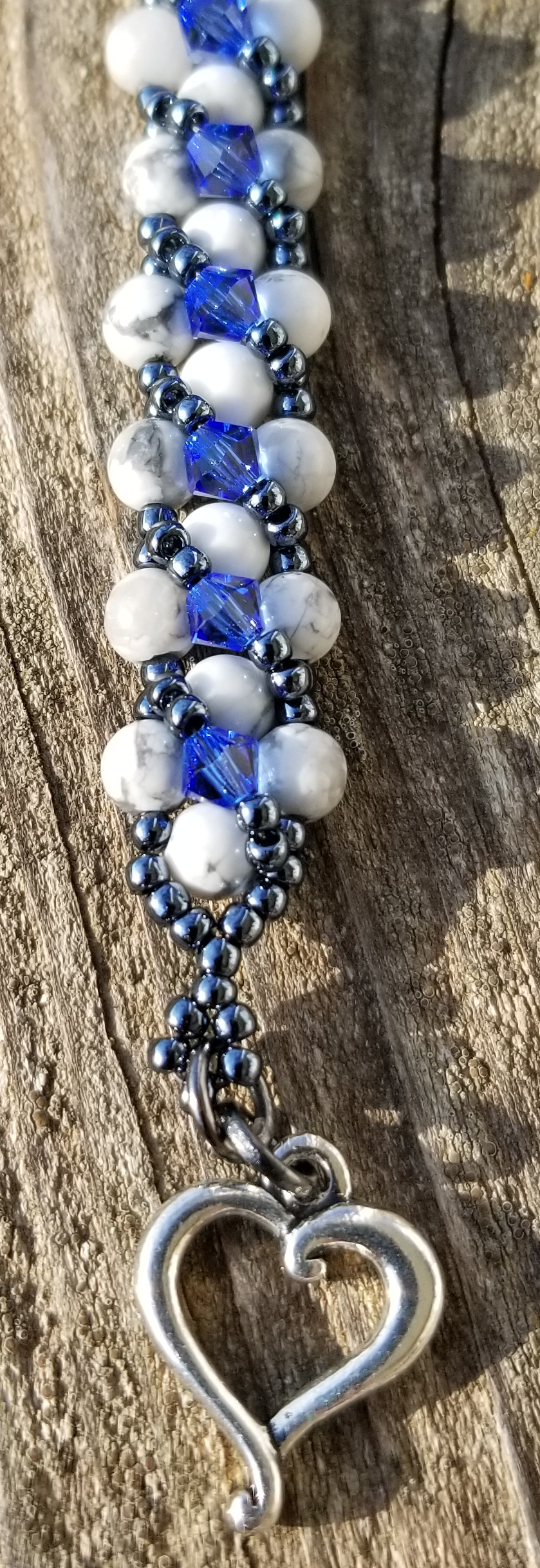 a blue and white beaded bracelet with a heart toggle clasp