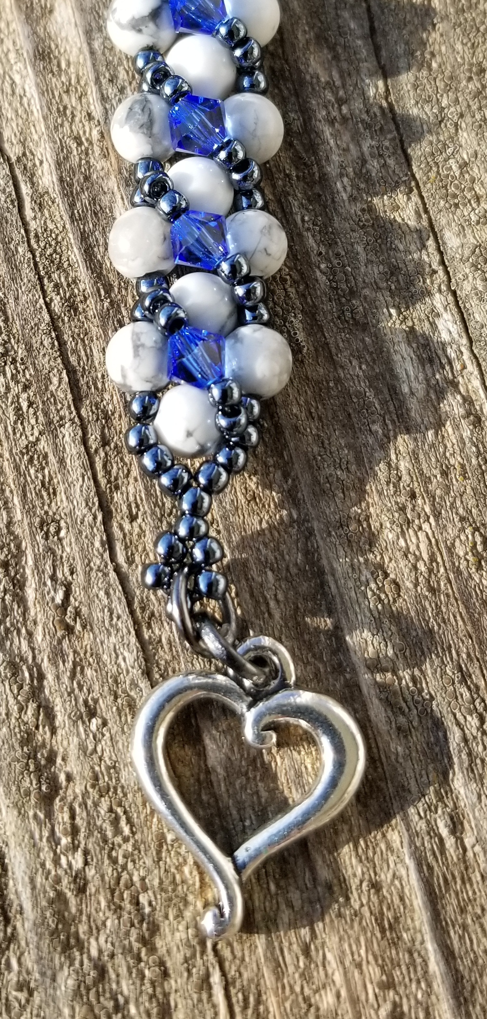 a blue and white beaded bracelet with a heart charm