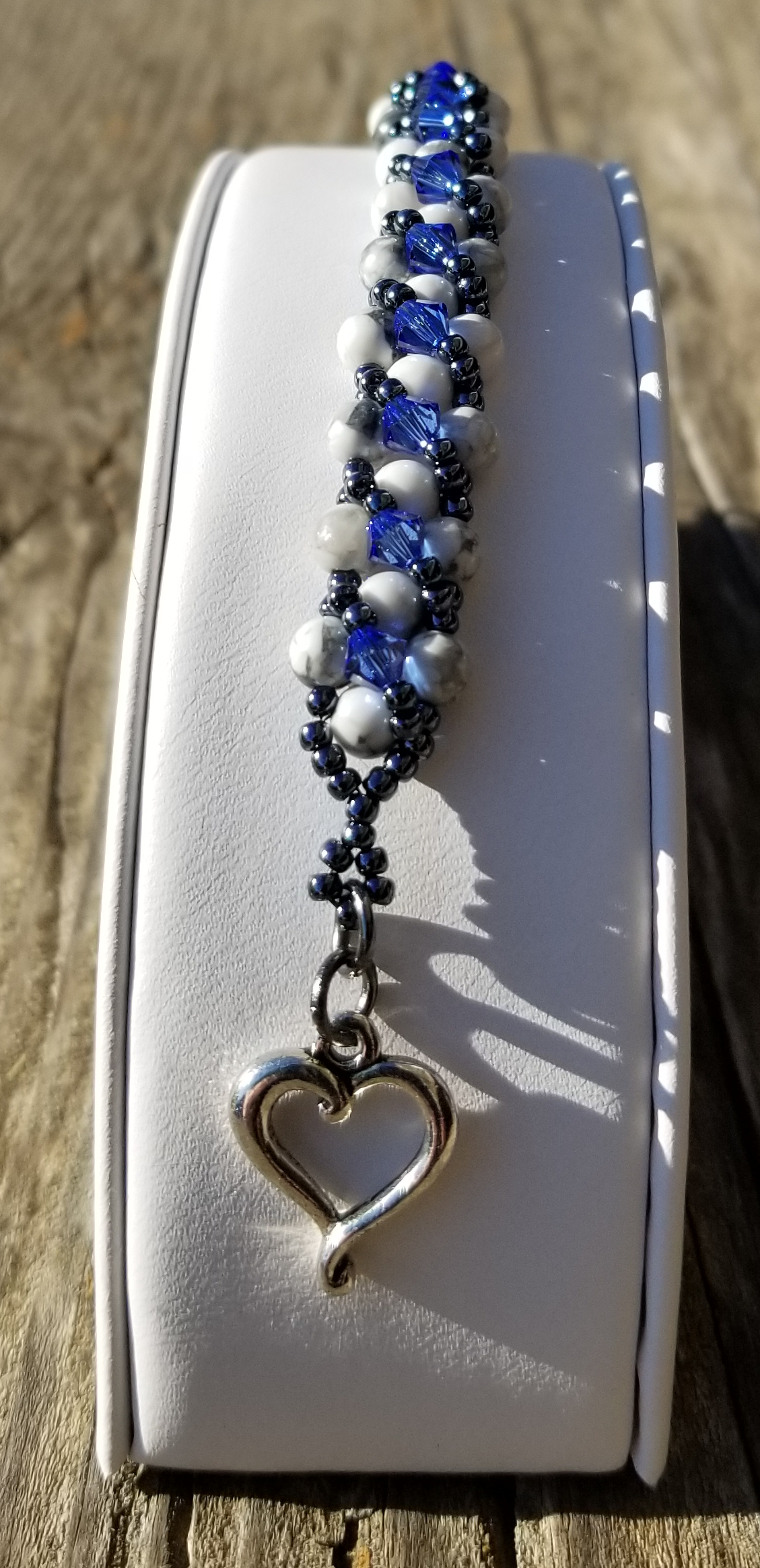 a blue and white beaded bracelet with a heart charm