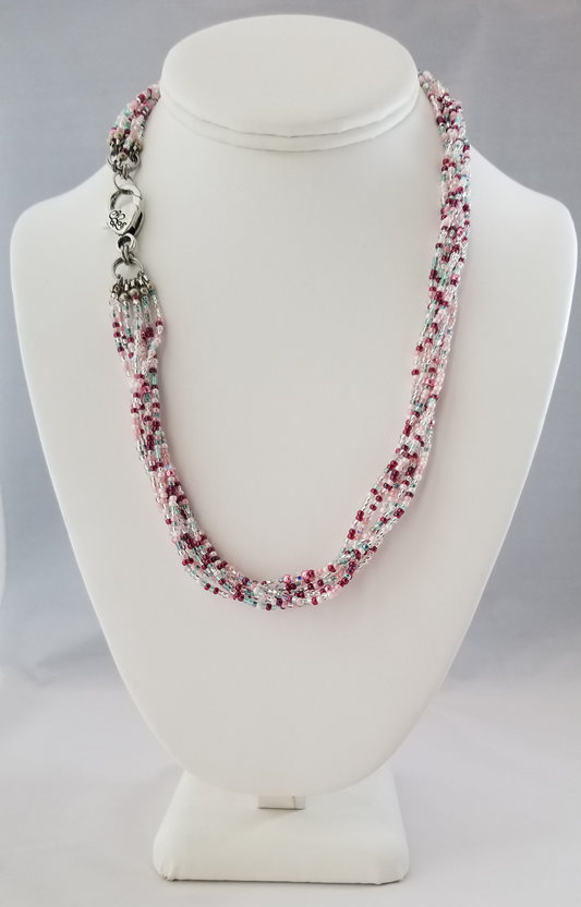 a white mannequin with a necklace on top of it