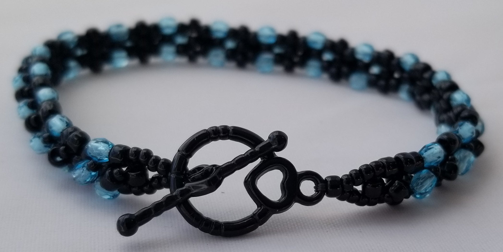 a black and blue beaded bracelet with a heart