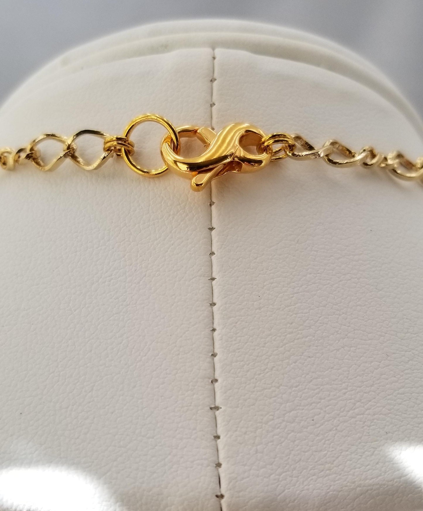 a close-up view of a gold necklace with a clasp and chain.