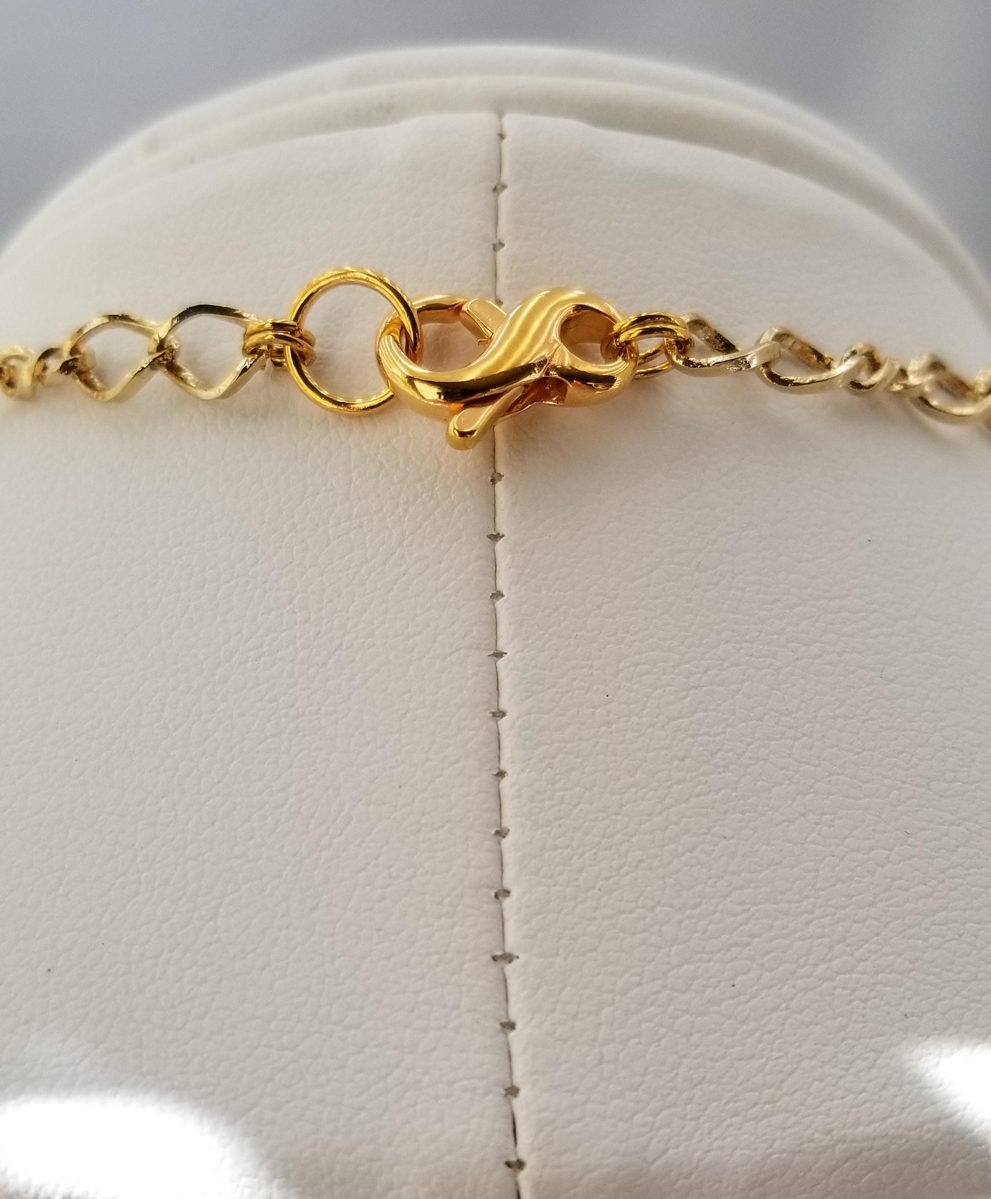 a close-up view of a gold necklace with a clasp and chain.