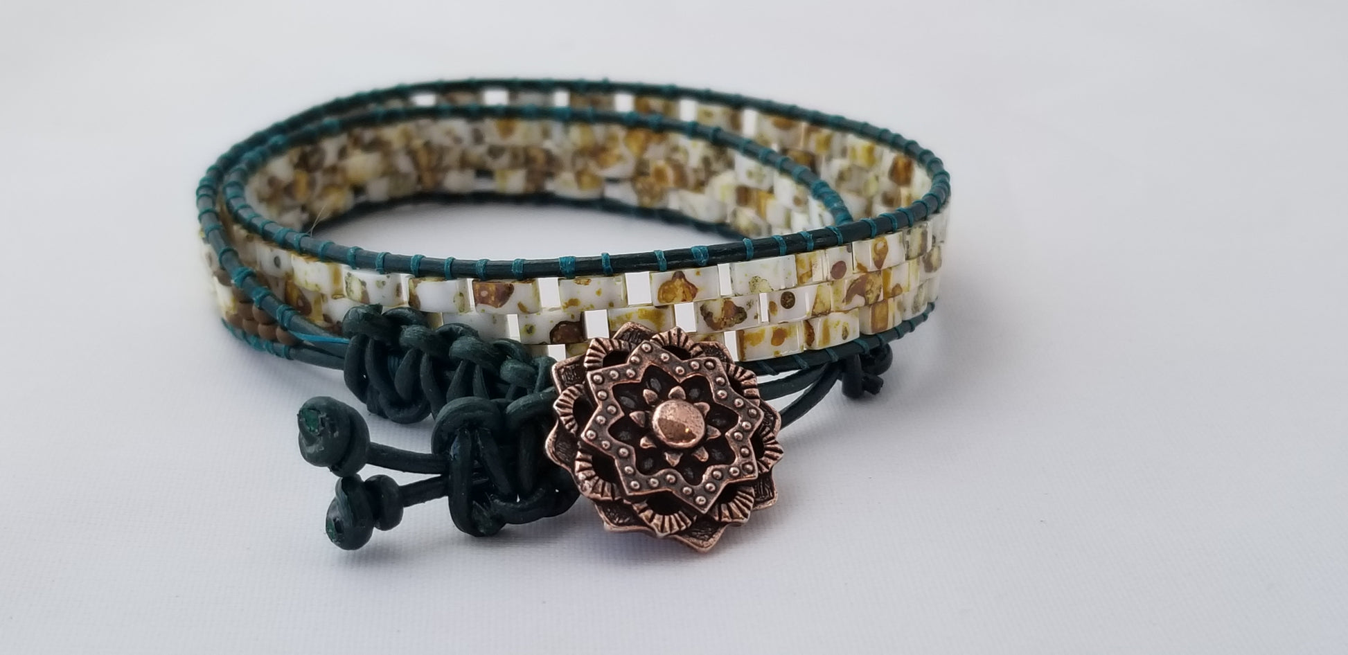 a close up of a bracelet with a flower on it