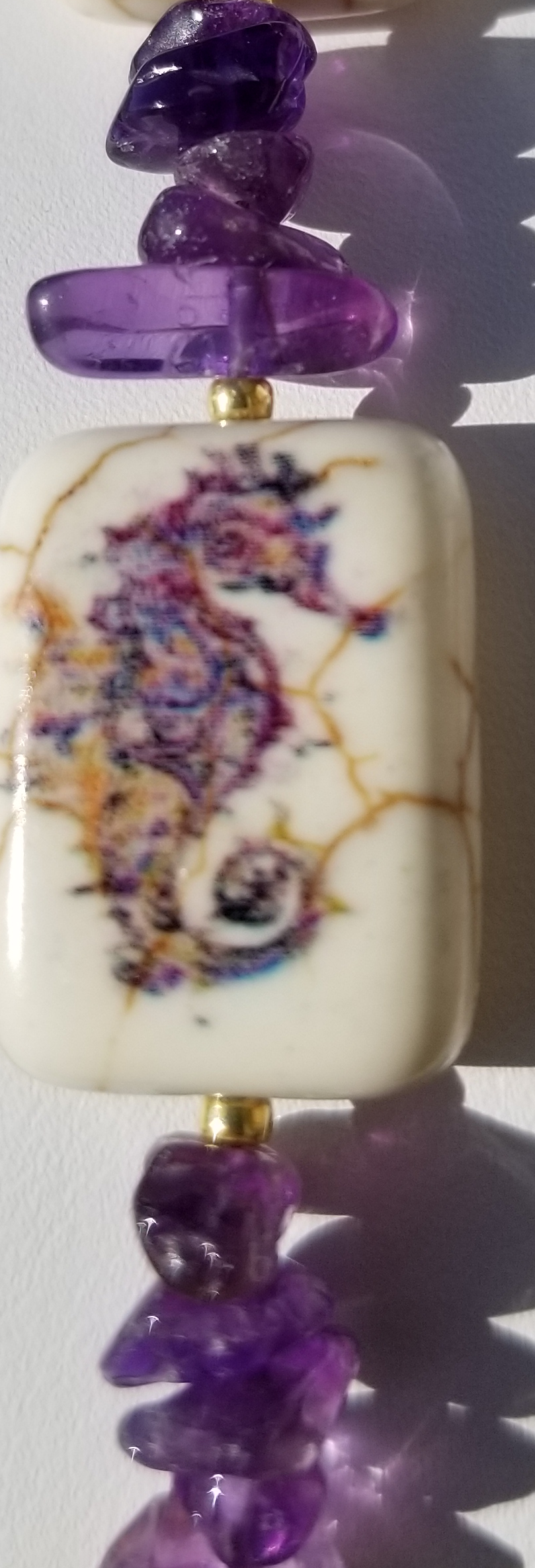 a white and purple bead with a lion head on it