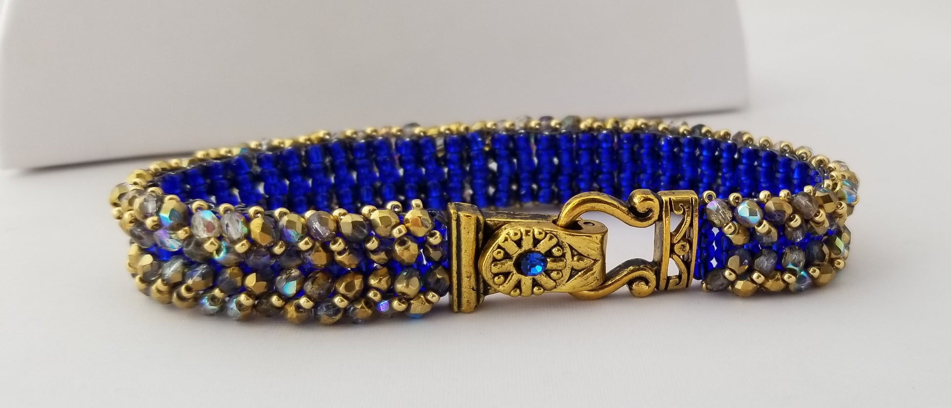 a blue and gold beaded bracelet with a lock